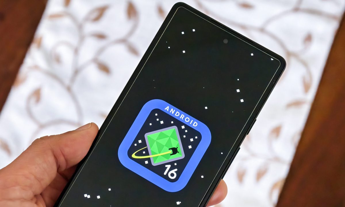 Android 16 logo on Google Pixel 6a held in hand.