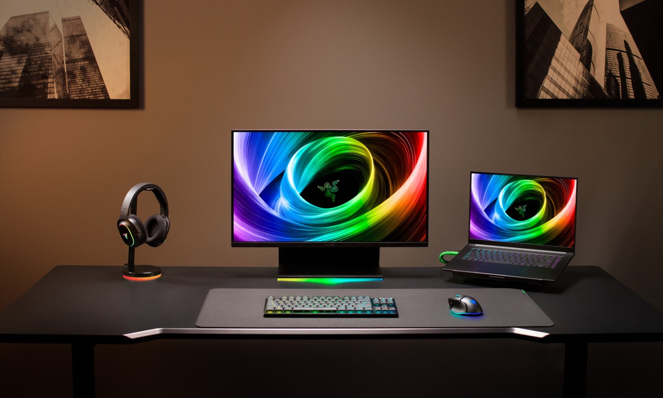 Razer Blade 16 on a gaming desk with doc station, monitor, and headphones